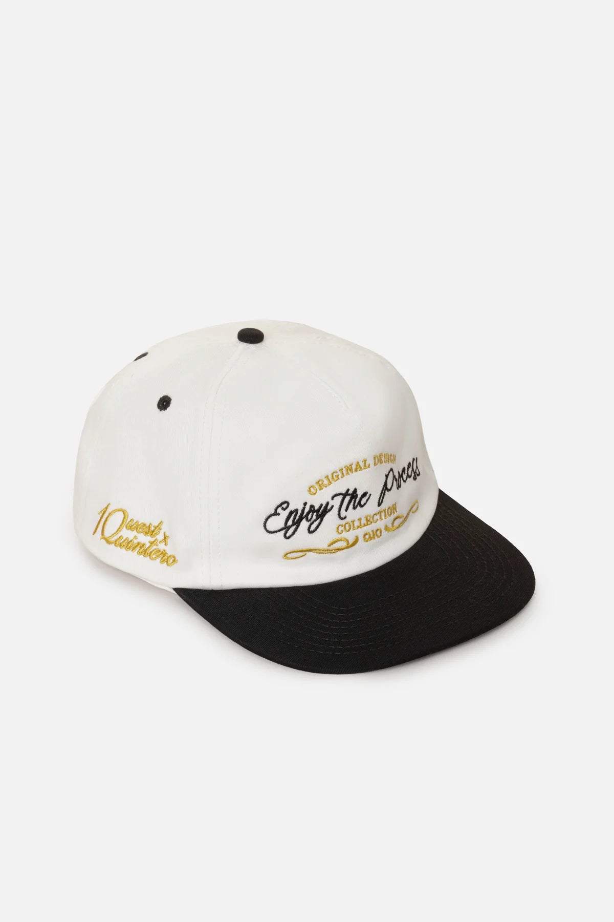 GORRA BEISBOLERA EN BLOQUES DE COLOR BEIGE CON BORDADO MARCA QUEST X JUAN FERNANDO QUINTERO