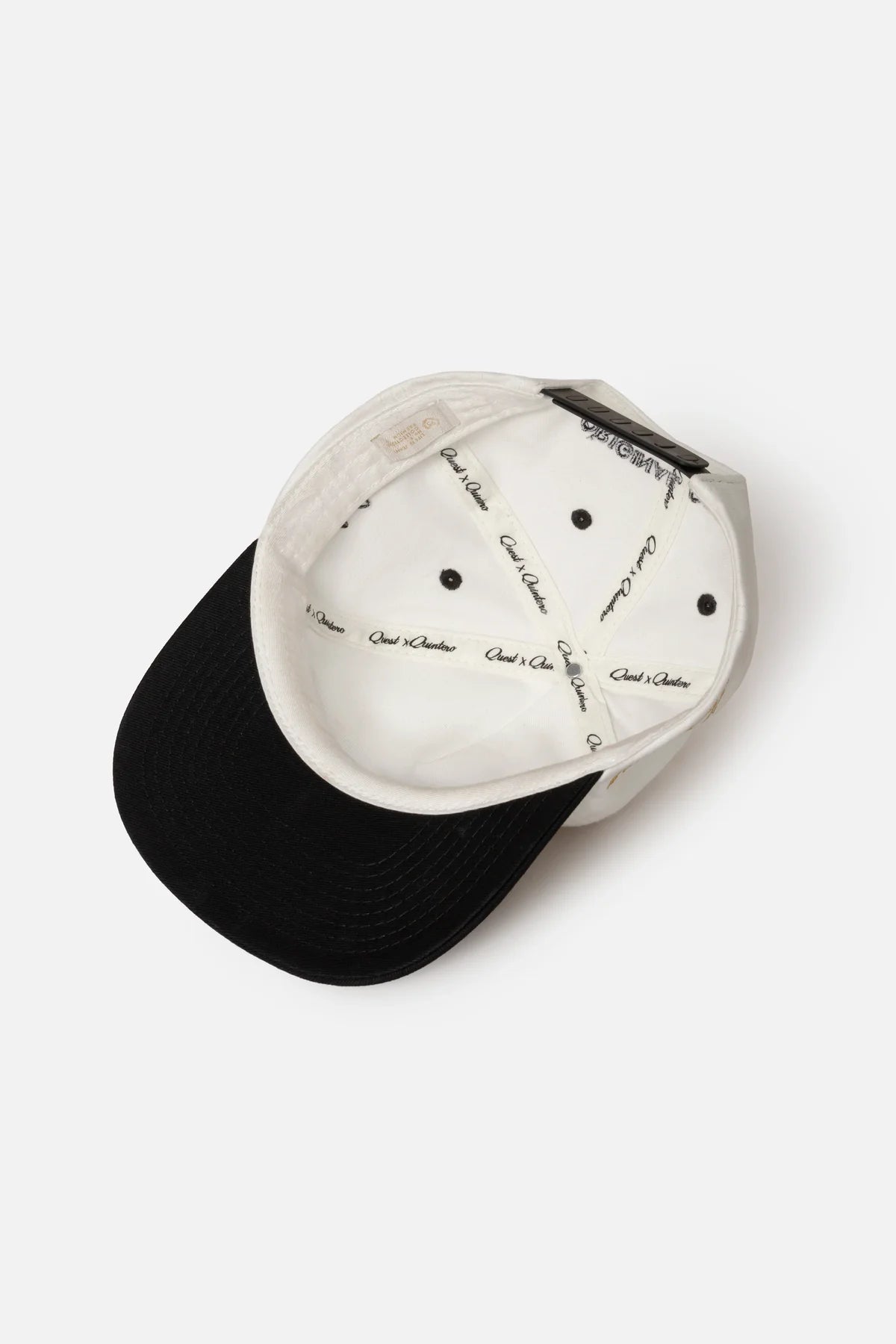 GORRA BEISBOLERA EN BLOQUES DE COLOR BEIGE CON BORDADO MARCA QUEST X JUAN FERNANDO QUINTERO